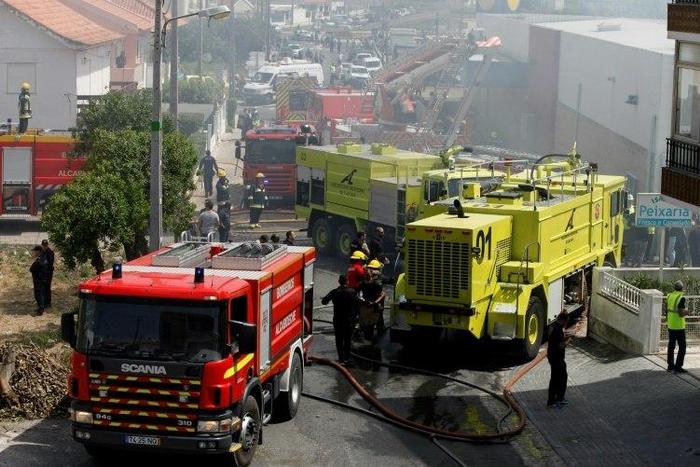 Rescue crews work after a plane crashed into a supermarket warehouse in Tires, near Sintra on April 17, 2017