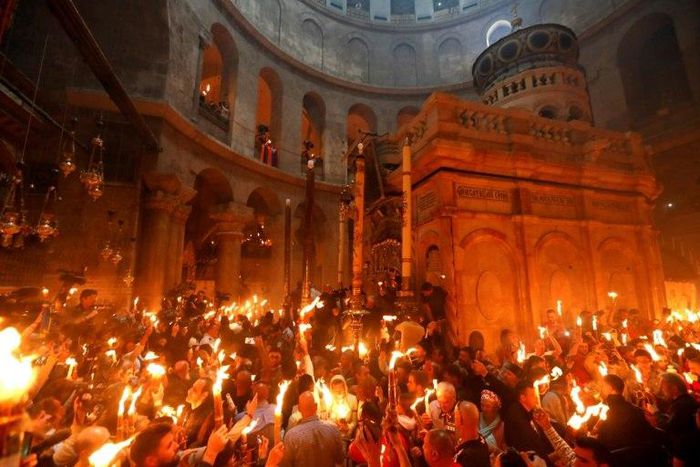 Christian Orthodox worshippers hold candles during the ceremony of the "Holy Fire" in the Church of the Holy Sepulchre in Jerusalem's Old City on April 15, 2017