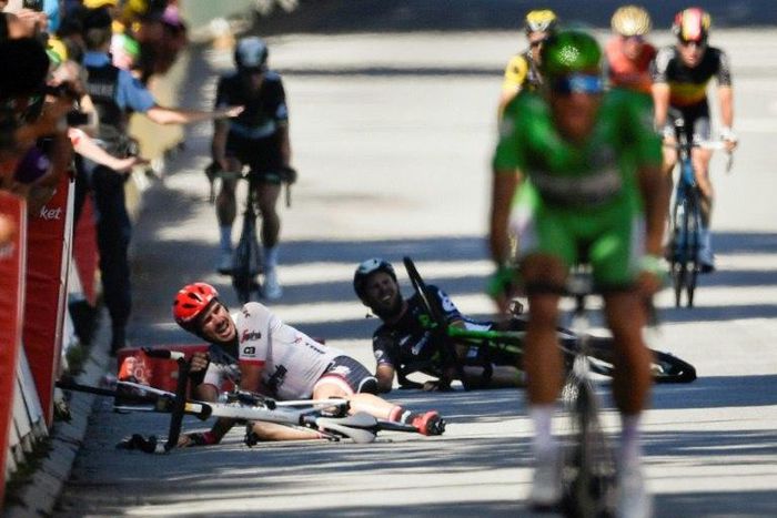 Germany's John Degenkolb (L) and Great Britain's Mark Cavendish (2ndL) lie on the ground after falling near the finish line at the end of the fourth stage of the 104th edition of the Tour de France July 4, 2017 between Mondorf-les-Bains and Vittel
