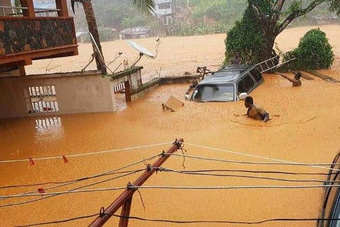 Residents struggled to traverse roads that were turned into churning rivers of mud after Sierra Leone's capital of Freetown was struck by heavy rains