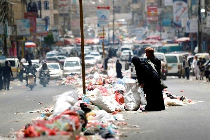 Yemenis salvage for discarded items in piles of rubbish lining a road in Sanaa on May 9, 2017