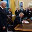President Trump signing memoranda in the Oval Office on Monday.