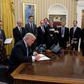 President Trump signing memoranda in the Oval Office on Monday.