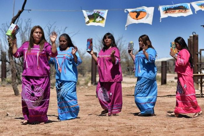 Indigenous people from the Tohono O'odham ethnic group dance and sing to protest against US President Donald Trump's intention to build a new wall in the border between Mexico and United States, in the Altar desert, northern Mexico