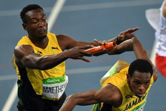 Jamaica's Nathon Allen (right) grabs the baton from Peter Matthews as they compete in the Men's 4x400m Relay Final at the Rio 2016 Olympic Games on August 20, 2016