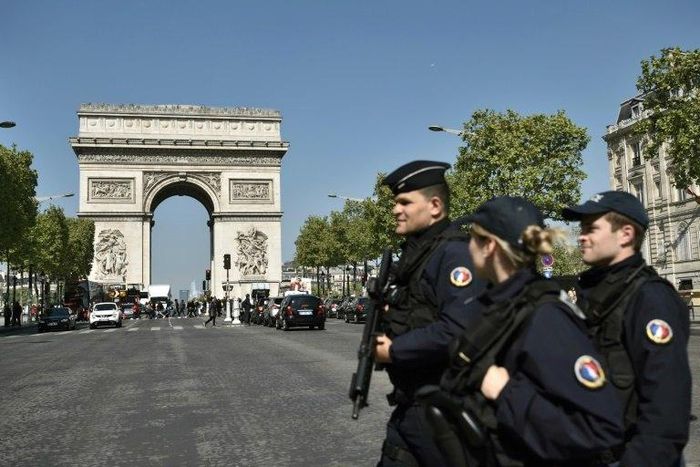 French Police officers patrol the Champs Elysees avenue near the Arc de Triomphe monument in Paris on April 21, 2017, a day after a gunman opened fire on police nearby on the avenue, killing a policeman and wounding two others