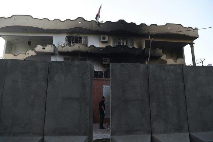 An Afghan security personnel stands at the entrance of the Iraqi embassy building after an attack in Kabul on Monday