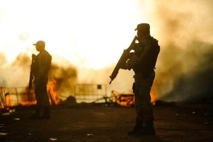Brazilian riot police stand guard near makeshift barricades as 220 inmates from the Alcacuz Penitentiary Center are transferred to another jail on January 18, 2017