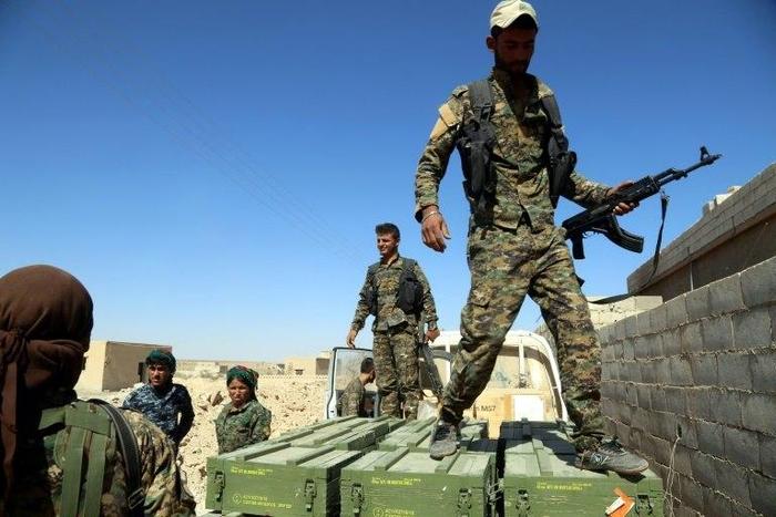 SDF fighters unload boxes of ammunition supplied by the US-led coalition in a village north of Raqa on June 7, 2017