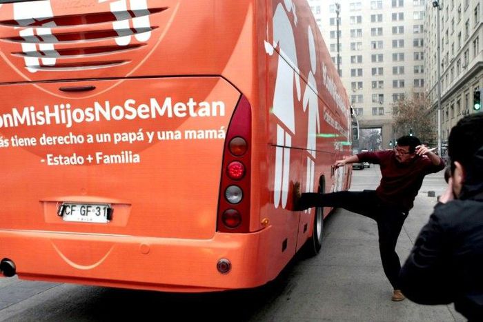 A pro-choice activist kicks the bus chartered by a conservative group opposed to gay rights in Chile's capital July 10, 2017.