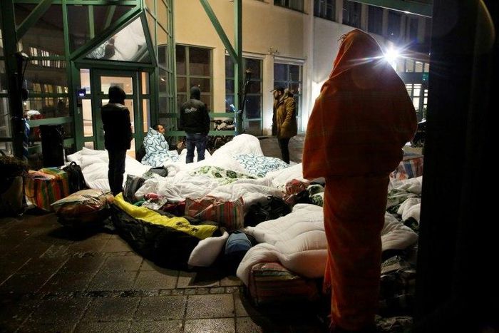 Refugees sleep outside the entrance of the Swedish Migration Agency's arrival center for asylum seekers at Jagersro in Malmo, Sweden, in November 2015