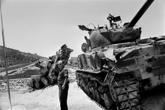 An Israeli soldier checks a destroyed tank on the road between Bethleem and Jerusalem in June 1967 during the Six-Day War