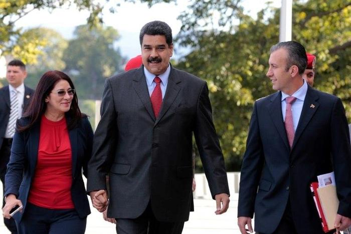 Handout picture released by the Venezuelan presidency showing President Nicolas Maduro (C) walking with his wife Cilia Flores (L) and new Vice-President Tareck El Aissami in Caracas on January 4, 2017