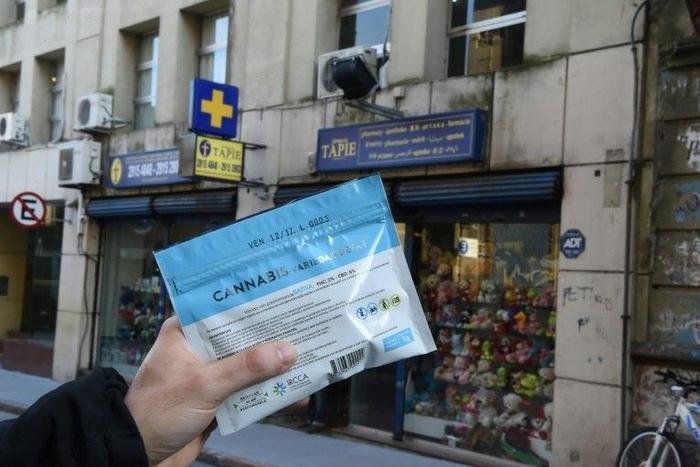 A man holds an envelope of marijuana that he purchased at a pharmacy in Montevideo in this file photo from July 19