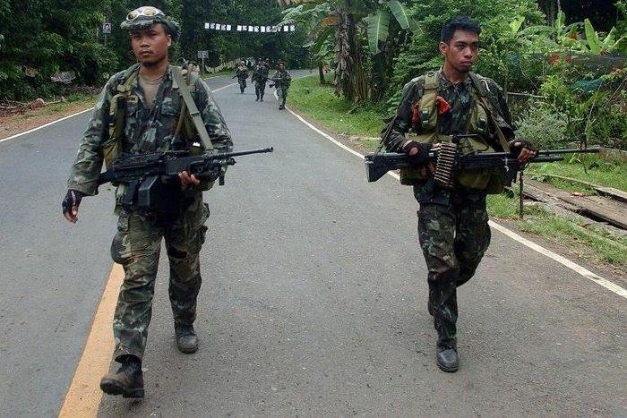 Philippine marines patrol a road on Basilan island, stronghold of the notorious Abu Sayyaf kidnap-for-ransom group, who killed nine in a dawn attack Monday according to police