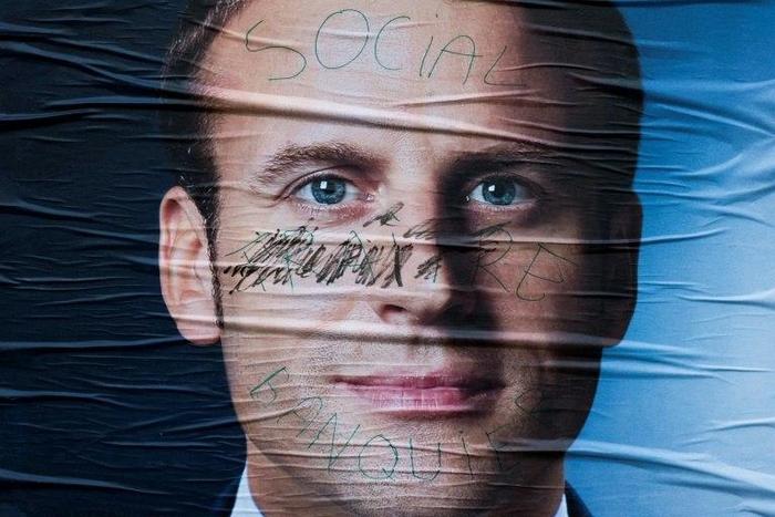 A vandalised campaign poster for French presidential election candidate Emmanuel Macron Emmanuel Macron is seen on May 5, 2017 in Paris