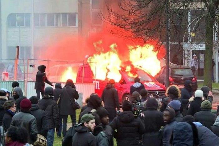 Image grab taken from an AFPTV video shows a van of radio station RTL burning during clashes on the edge of a rally in Bobigny, outside Paris on February 11, 2017 to denounce police brutality after a black man was allegedly raped