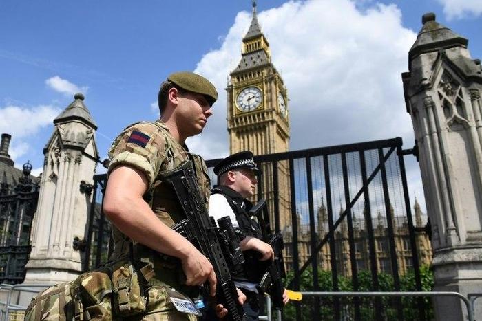 A British soldier and armed police officer patrol near the Houses of Parliament in central London on May 24, 2017