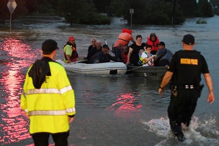 People are rescued from the Omni hotel by boat after Hurricane Harvey caused heavy flooding in Houston