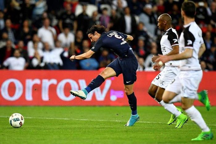Paris Saint-Germain's Uruguayan forward Edinson Cavani (L) scores his second goal during the French L1 football match between Paris Saint-Germain and Guingamp at the Parc des Princes stadium, in Paris, on April 9, 2017