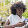 A frustrated young Nigerian scrolling through her phone — symbolising how digital loan apps prey on vulnerable borrowers amid rising inflation. [Getty Images/Stock Photo]