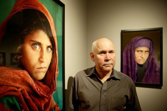 US photographer Steve McCurry poses next to his photos of the "Afghan Girl", Sharbat Gula, at a 2013 exhibition in Hamburg, northern Germany