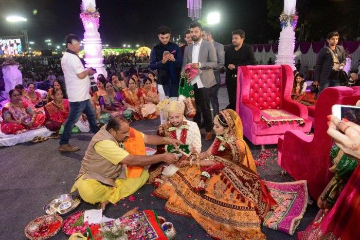 Hundreds of brides in colourful ethnic attire and ornate jewellery performed their wedding rituals in front of thousands of guests in the city of Surat
