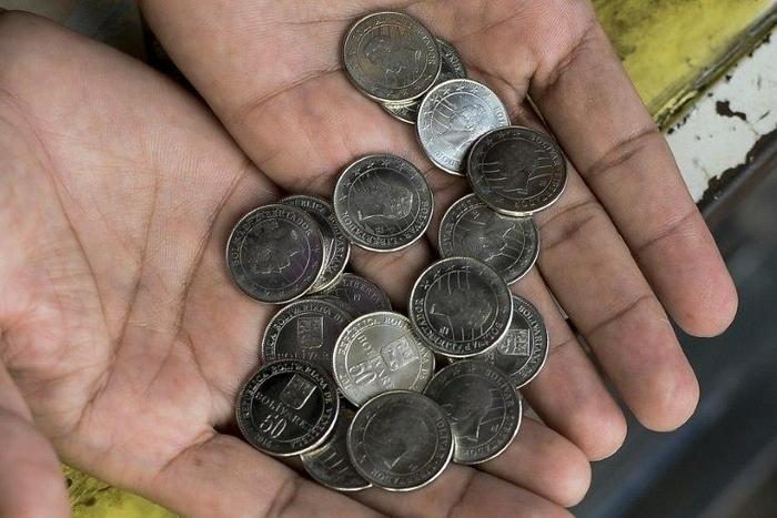 A man shows new 50-Bolivar-coins at a kiosk in Caracas on December 28, 2016