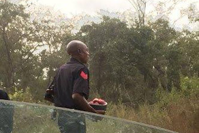A policeman holds a helmet filled with onions.