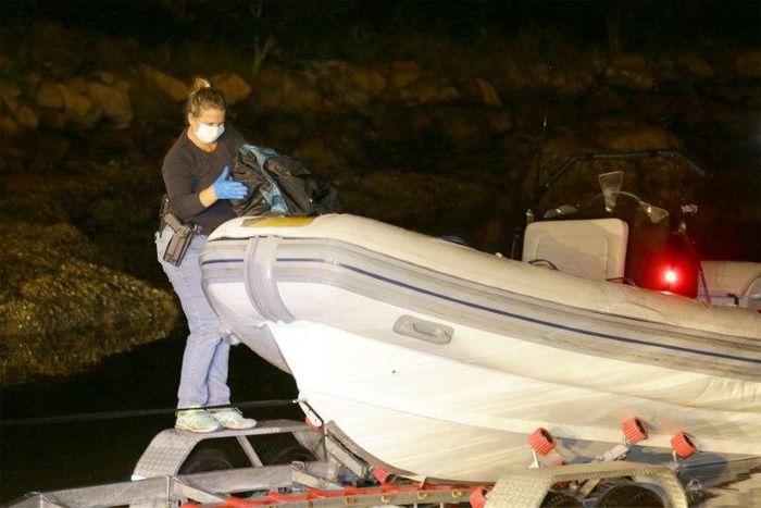A New South Wales police officer seizes cocaine from an inflatable boat at Brooklyn on the Central Coast near Sydney