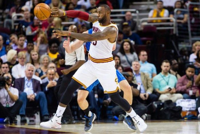 LeBron James of the Cleveland Cavaliers passes while under pressure from Jeff Green of the Orlando Magic during the game on October 5, 2016 in Cleveland, Ohio
