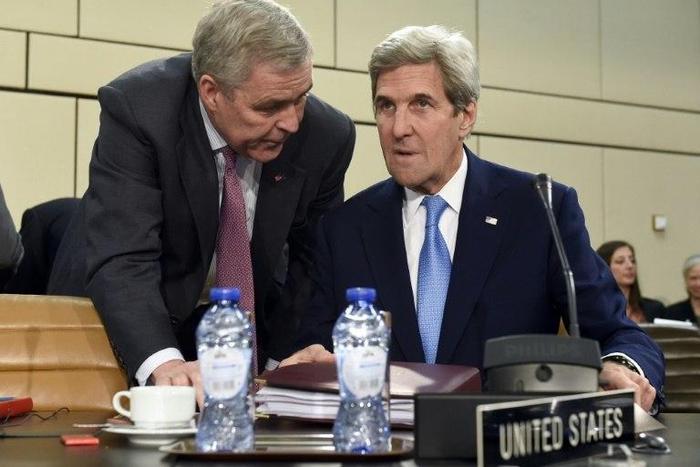 US Secretary of State John Kerry (R) listens to US ambassador to the NATO Douglas Lute during a meeting in Brussels on December 6, 2016