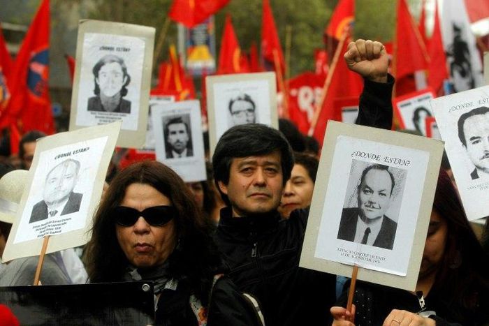 Human rights activists hold pictures of missing people during a march in Santiago, in September 2016, commemorating the 43rd anniversary of the military coup led by General Augusto Pinochet that deposed President Salvador Allende