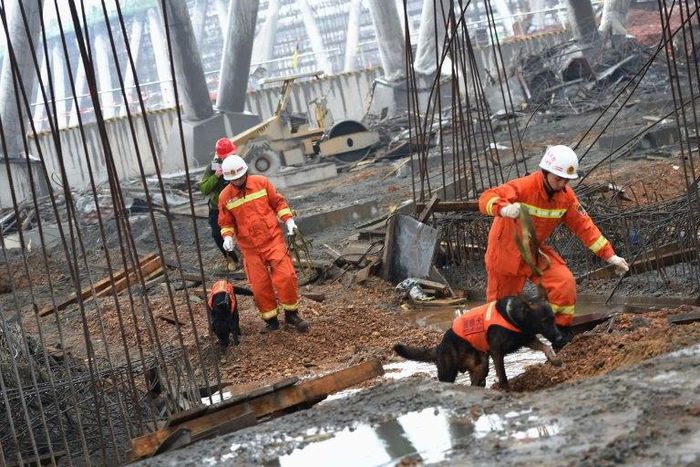 Rescue workers search through the remains of a collapsed platform in a cooling tower at Fengcheng on November 25, 2016