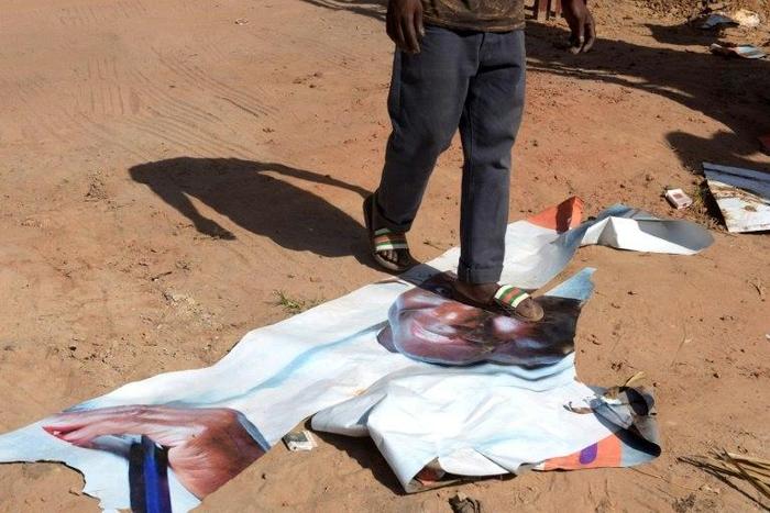 A man walks on a ripped electoral poster of Gambia's outgoing president Yahya Jammeh, in a street of Bijilo, on December 4, 2016