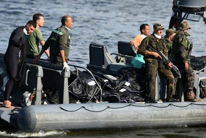 Egyptian medics arrive by boat with the bodies of migrants whose boat capsized in the Mediterranean, at the Egyptian port city of Rosetta