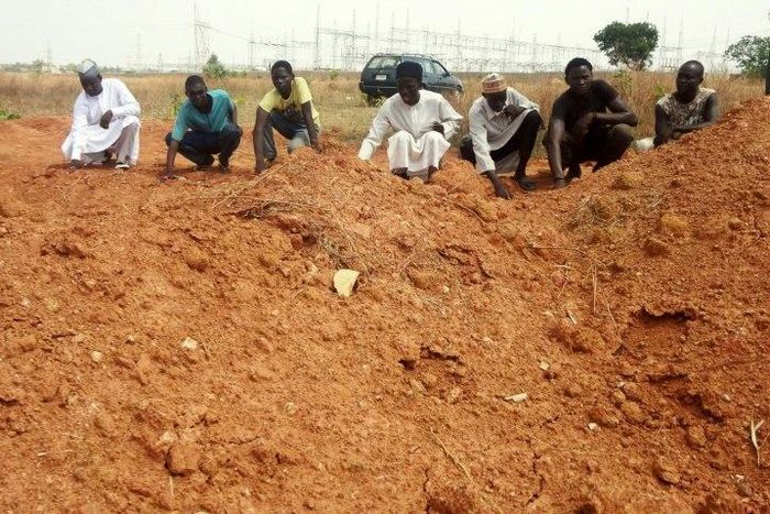 Members of the Islamic Movement of Nigeria (IMN), a Shiite group, pray at a mass grave in the outskirts of northern Nigerian city of Kaduna