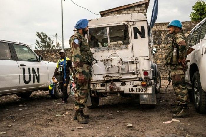 Indian Blue Helmet peacekeepers stand guard next to United Nations vehicles in Goma on November 8, 2016