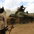 A military personnel gestures next to a tank after the Sudanese Armed Forces (SAF) and the Rapid Support Forces (RSF) recaptured the Daldako area, outside the military headquarters in Kadogli May 20, 2014.