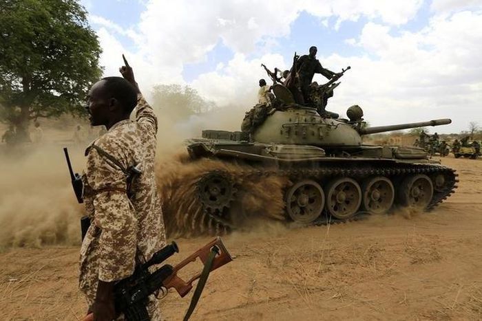 A military personnel gestures next to a tank after the Sudanese Armed Forces (SAF) and the Rapid Support Forces (RSF) recaptured the Daldako area, outside the military headquarters in Kadogli May 20, 2014.