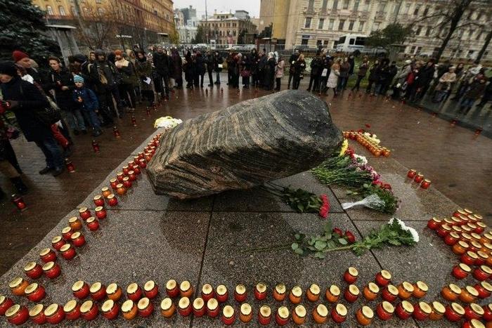 People place candles and flowers at the memorial for the victims of the Soviet-era political repression, the Solovky Stone monument, on Lubyanka Square in Moscow on October 29, 2016