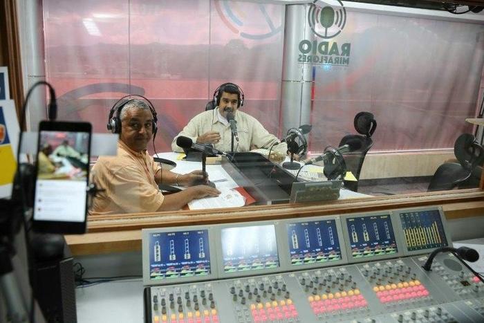 Venezuelan president Nicolas Maduro (R) speaks during his radio broadcast 'La Hora de la salsa' (Salsa Time), in Caracas, on November 15, 2016