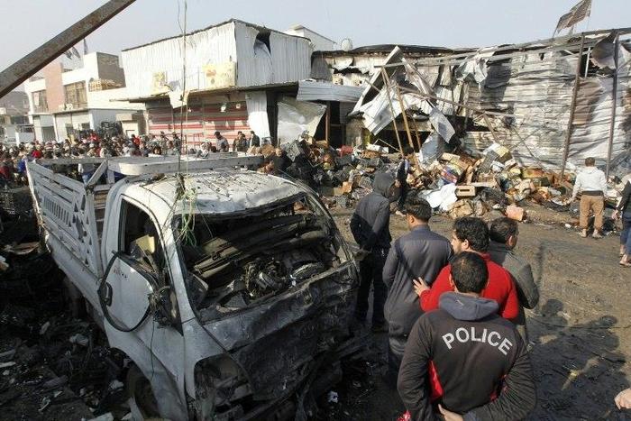 Iraqis inspect the site of an attack at Baghdad's main vegetable market on January 8, 2017