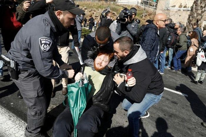 Israeli police detain a demonstrator during a protest outside the defence ministry in Tel Aviv on January 4, 2017, in support of Israeli soldier Elor Azaria
