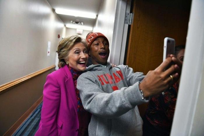 Hillary Clinton poses with singer Pharrell Williams for a selfie backstage before a campaign rally in Raleigh, North Carolina