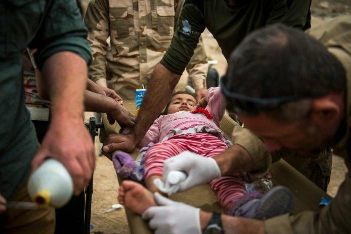 Front line medics from the Iraqi Special Forces 2nd division and volunteers from the Slovak charity Academy of Emergency Medicine treat an Iraqi girl with a shrapnel wound in the Samah neighbourhood of Mosul on November 15, 2016