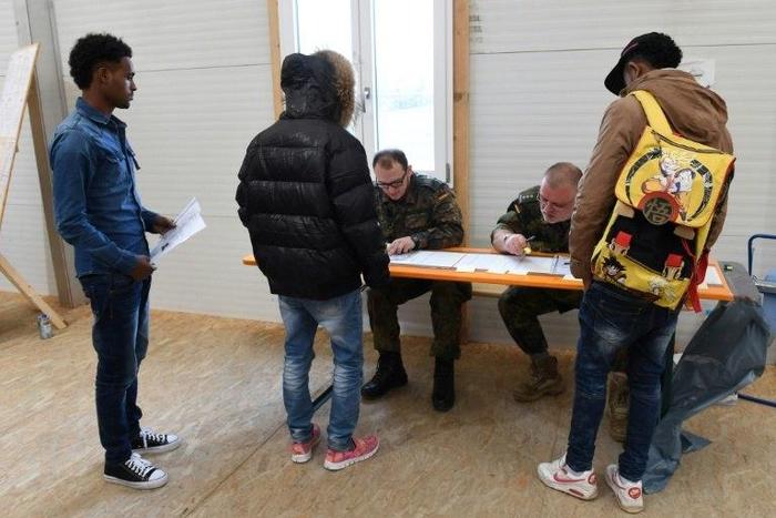 Newly arrived migrants line up at a registration point in Erding near Munich, southern Germany, on November 15, 2016