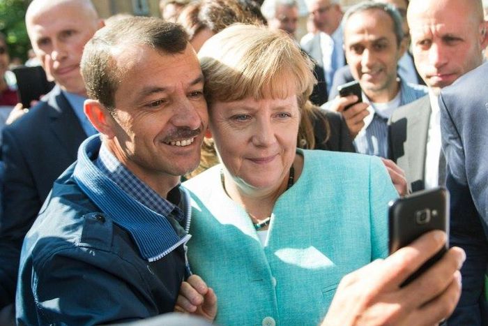 An asylum seeker takes a selfie with Angela Merkel in Berlin