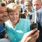 An asylum seeker takes a selfie with Angela Merkel in Berlin