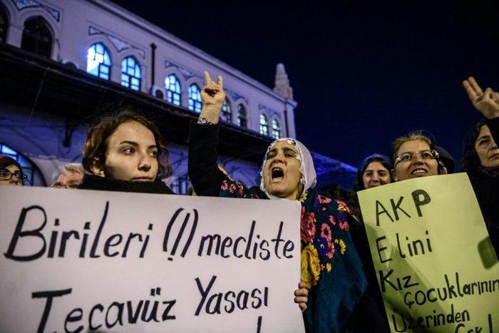 Women shout slogans and hold placards reading "Rape is a human crime" (L) and "AKP get your hands off our children" during a demonstration in Istanbul on November 18, 2016